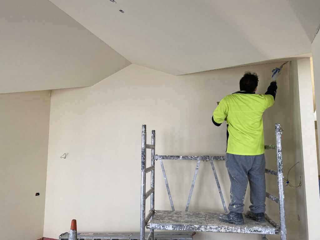 Tradesperson installing and finishing GIB® plasterboard on interior walls and ceilings during a residential build in New Zealand