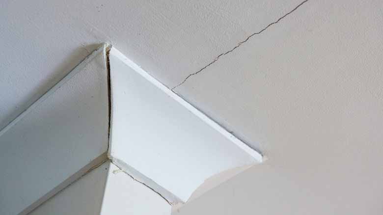 Ceiling crack running from cornice across a painted plasterboard ceiling in an Auckland, New Zealand home
